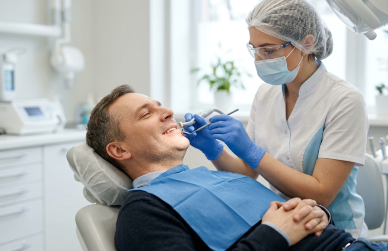 Patient relaxed during dental implant procedure with dentist ensuring comfortable and pain-free treatment